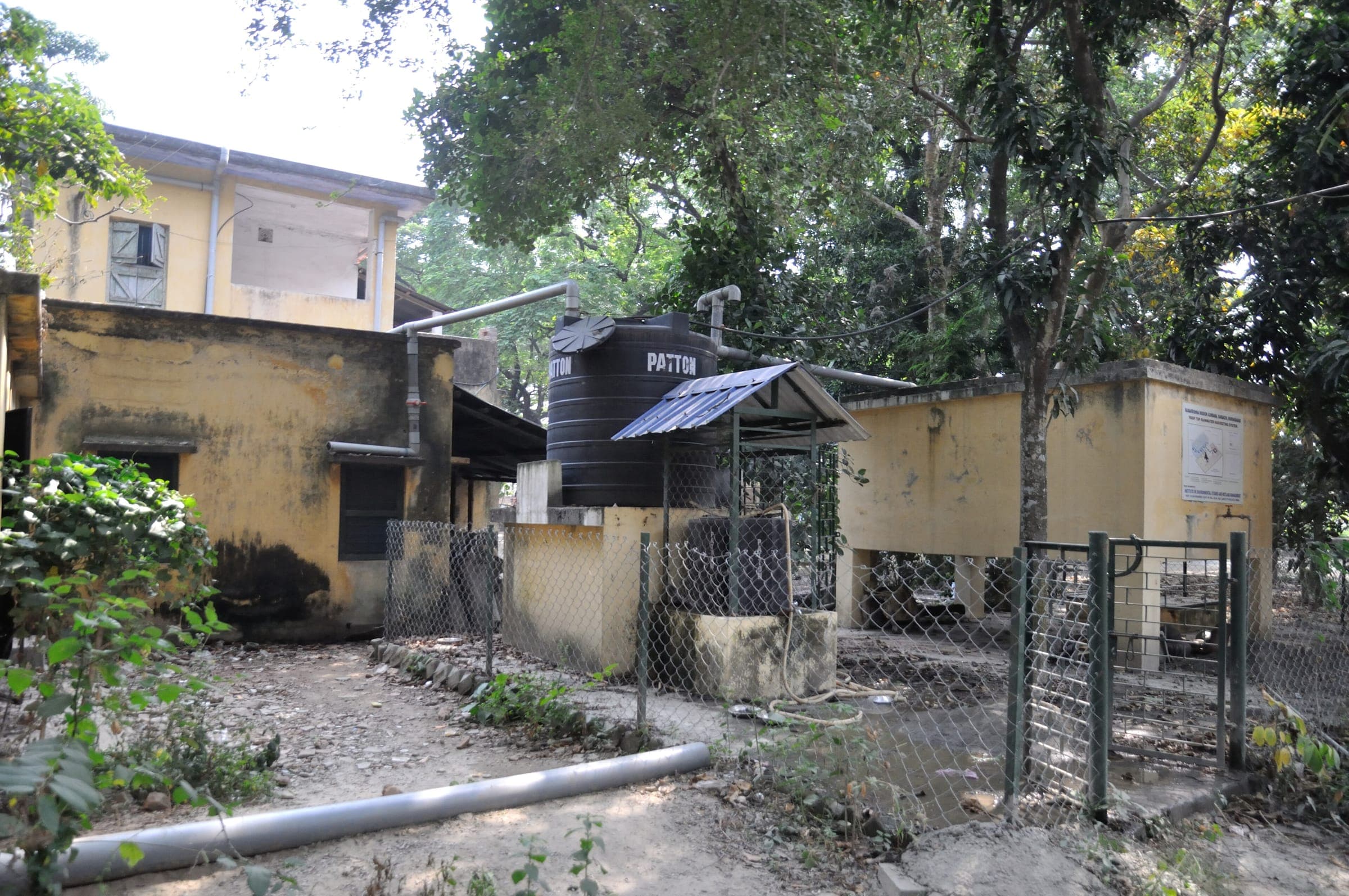 Rooftop rainwater harvesting pipes and storage at a campus in Murshidabad, West Bengal